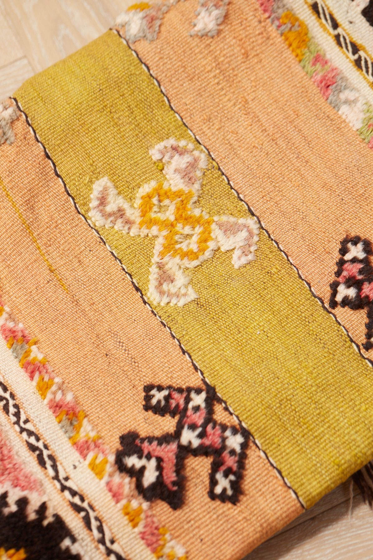 The Desert Rose green, pink pastel coloured wool rug with geometric patterns.
